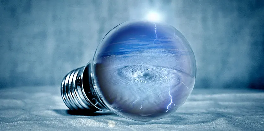Bombilla sobre fondo azul con imagen de un torbellino y relámpagos en su interior. Representa la eficiencia energética y asesoría sobre tarifas de luz para 2025.